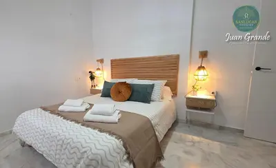 a bedroom with a large bed with towels on it at Apartamentos Turísticos Juan Grande by Sanlúcar Housing in Sanlúcar de Barrameda