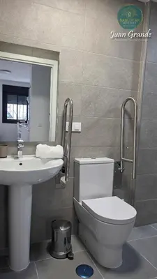 a bathroom with a toilet and a sink at Apartamentos Turísticos Juan Grande by Sanlúcar Housing in Sanlúcar de Barrameda
