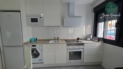 a white kitchen with a sink and a dishwasher at Apartamentos Turísticos Juan Grande by Sanlúcar Housing in Sanlúcar de Barrameda