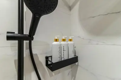 a black holder with three white bottles on a wall at Casa Palacio Marqués de Castellanos in Jerez de la Frontera