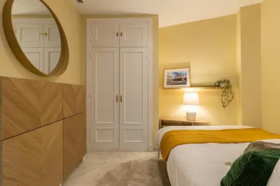 a bedroom with two beds and a mirror at Casa Palacio Marqués de Castellanos in Jerez de la Frontera