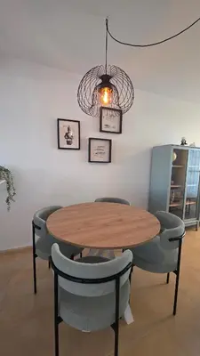 a dining room table with chairs and a chandelier at La San Sebastián del Sur by Sanlúcar Housing in Sanlúcar de Barrameda