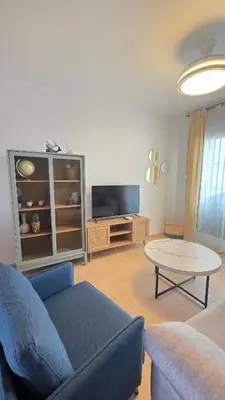 a living room with a blue couch and a table at La San Sebastián del Sur by Sanlúcar Housing in Sanlúcar de Barrameda