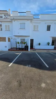 a white building with a parking lot in front of it at La San Sebastián del Sur by Sanlúcar Housing in Sanlúcar de Barrameda