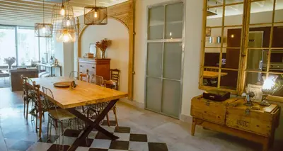 a dining room with a wooden table and chairs at Apartamento Bizcocheros con piscina y jardín privado in Jerez de la Frontera