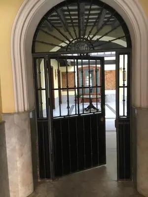 an entrance to a building with a black door at Apartamento Bizcocheros con piscina y jardín privado in Jerez de la Frontera