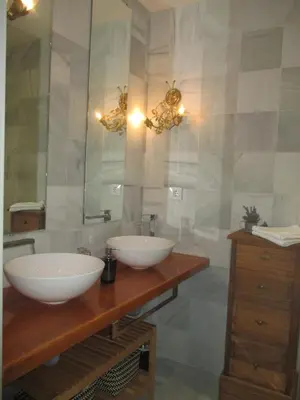 a bathroom with two white sinks and a mirror at Apartamento Bizcocheros con piscina y jardín privado in Jerez de la Frontera
