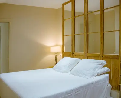 a bedroom with a white bed with a mirror at Apartamento Bizcocheros con piscina y jardín privado in Jerez de la Frontera
