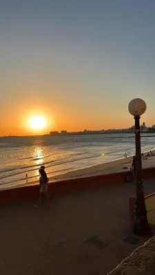 a couple walking on the beach at sunset at Playa, Sol y Relax in Cádiz