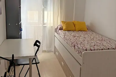 a small bedroom with a bed and a desk at Playa, Sol y Relax in Cádiz