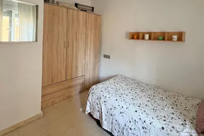a bedroom with a bed and a wooden cabinet at Playa, Sol y Relax in Cádiz