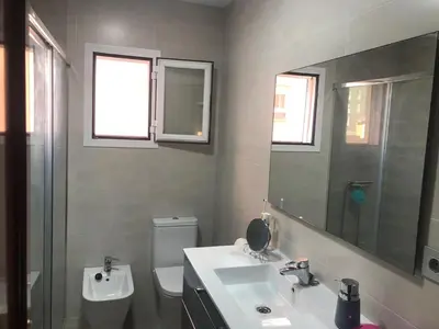 a bathroom with a sink and a toilet and a mirror at Playa, Sol y Relax in Cádiz