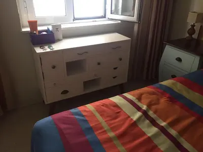 a bedroom with a bed with a dresser and a window at Playa, Sol y Relax in Cádiz