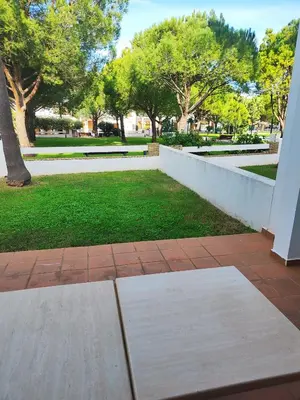 a park with benches and grass and trees at Apartamento planta baja con jardín privado in Novo Sancti Petri