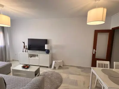 a living room with a couch and a tv at Puertas del Mar 1 in Puerto Real