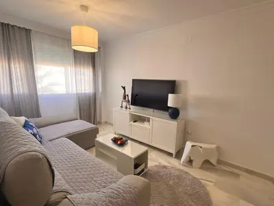 a living room with a couch and a flat screen tv at Puertas del Mar 1 in Puerto Real