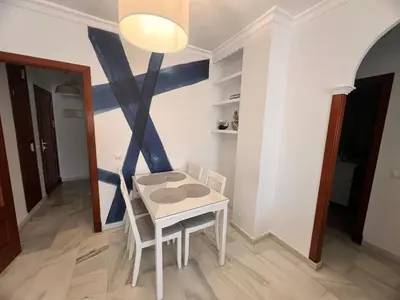 a small white table and chairs in a room at Puertas del Mar 1 in Puerto Real