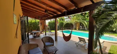 a patio with a hammock and a swimming pool at Casa Palmera in Conil de la Frontera