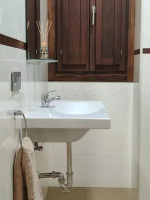 a bathroom with a white sink and wooden cabinets at Porvernir 10 in Jerez de la Frontera