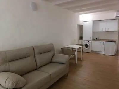 a living room with a couch and a kitchen at Apartamento Fino in Jerez de la Frontera