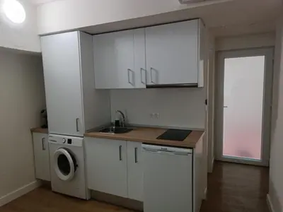 a kitchen with white cabinets and a washer and dryer at Apartamento Fino in Jerez de la Frontera