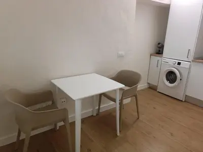 a white table and chairs in a room with a washing machine at Apartamento Fino in Jerez de la Frontera