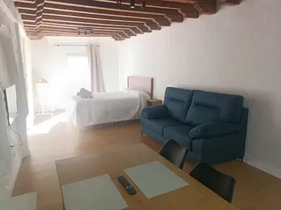 a living room with a blue couch and a bed at Apartamento El Taranto in Jerez de la Frontera