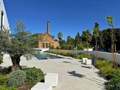 a courtyard with white benches in front of a church at Sherry de la Riva - Ole Solutions in Jerez de la Frontera