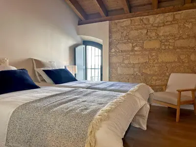a bedroom with a large bed and a stone wall at Sherry de la Riva - Ole Solutions in Jerez de la Frontera