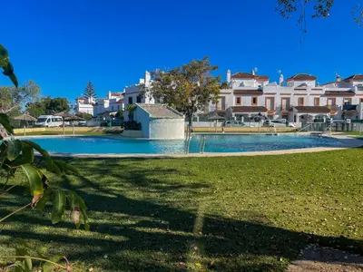 a swimming pool in a park with buildings in the background at Apartclub La Barrosa in Chiclana de la Frontera