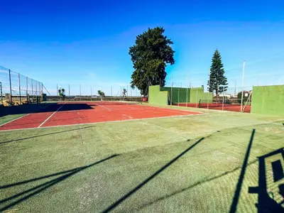 a tennis court with a net on top of it at Apartclub La Barrosa in Chiclana de la Frontera