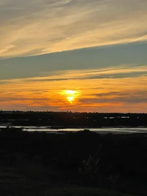 a sunset over a river with the sun in the sky at Apartclub La Barrosa in Chiclana de la Frontera
