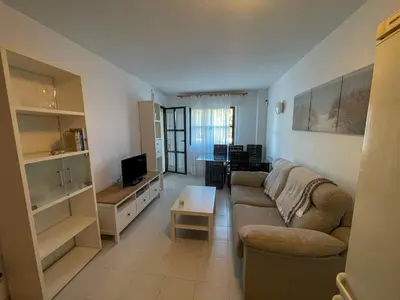 a living room with a couch and a table at Apartclub La Barrosa in Chiclana de la Frontera