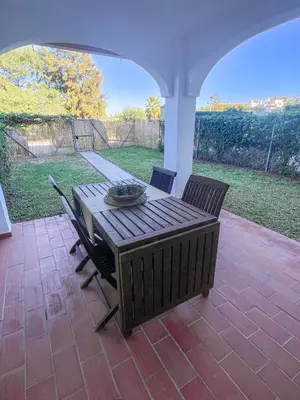 a wooden table and chairs on a patio at Apartclub La Barrosa in Chiclana de la Frontera