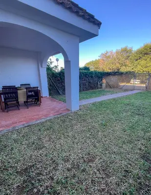 a patio with two benches on a brick patio at Apartclub La Barrosa in Chiclana de la Frontera