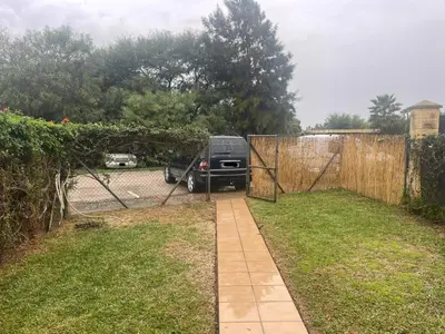 a car parked in a driveway next to a fence at Apartclub La Barrosa in Chiclana de la Frontera