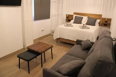 a living room with a couch and a bed at Apartamentos Sun 65 in Jerez de la Frontera