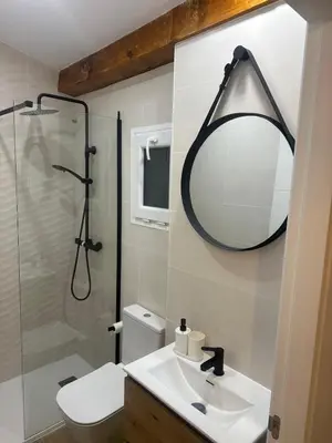 a bathroom with a shower and a sink and a mirror at Apartamentos Sun 65 in Jerez de la Frontera