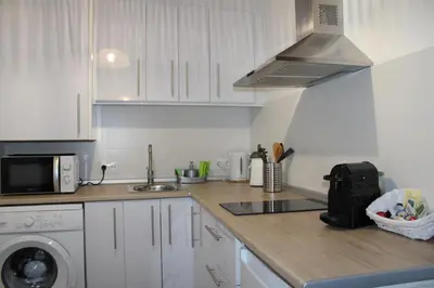 a kitchen with white cabinets and a sink and a microwave at Apartamentos Sun 65 in Jerez de la Frontera