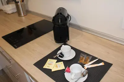 a kitchen counter with a coffee pot and cups on a mat at Apartamentos Sun 65 in Jerez de la Frontera