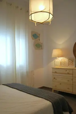 a bedroom with a bed and a lamp and a dresser at Tacita Investments,SL in Cádiz
