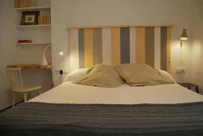 a bed with a striped headboard in a bedroom at Tacita Investments,SL in Cádiz