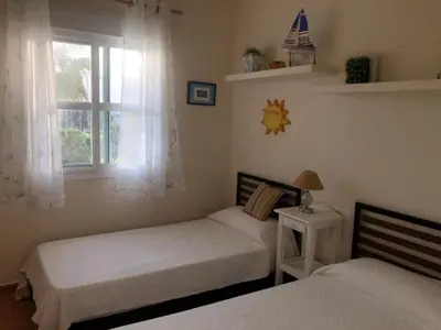 a bedroom with two beds and a window at Sonnige und ruhige Ferienwohnung am Golfplatz von Costa Ballena in Rota