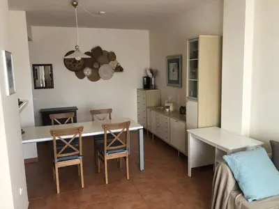 a kitchen with a table and chairs and a couch at Sonnige und ruhige Ferienwohnung am Golfplatz von Costa Ballena in Rota