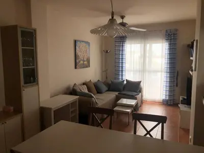 a living room with a couch and a table at Sonnige und ruhige Ferienwohnung am Golfplatz von Costa Ballena in Rota