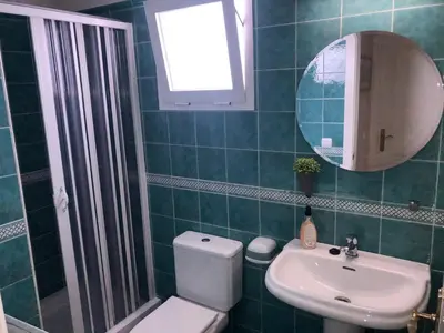 a bathroom with a toilet and a sink and a mirror at Sonnige und ruhige Ferienwohnung am Golfplatz von Costa Ballena in Rota