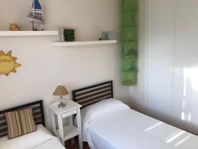 a bedroom with two beds and a side table at Sonnige und ruhige Ferienwohnung am Golfplatz von Costa Ballena in Rota