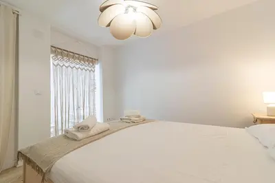a white bedroom with a large bed with towels on it at Allo Apartments Morenos I 2ºC Centro 1 habitación in Jerez de la Frontera