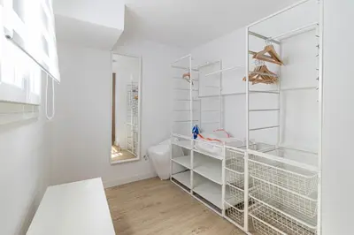 a white walk in closet with white shelves at Allo Apartments Morenos I 2ºC Centro 1 habitación in Jerez de la Frontera