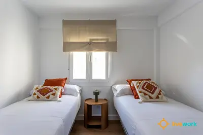 two twin beds in a room with a window at La Casa Bonita de la Victoria Livework By Cadiz Time in Cádiz